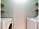 Laundry room features side by side washing machines with storage shelves at 2932 Lichen Ln # D, Clearwater, FL 33760