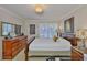 Cozy bedroom with a wood bed frame, bright window and a marble topped dresser with mirror at 3053 S Concordia Ave # A, Tampa, FL 33629