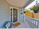Cozy front porch with neutral paint and inviting welcome mat with hanging flower baskets at 3053 S Concordia Ave # A, Tampa, FL 33629
