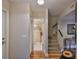 Hallway with hardwood floors leads to a bathroom and stairway with carpeted stairs at 3053 S Concordia Ave # A, Tampa, FL 33629