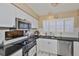 Cozy kitchen features stainless appliances, white cabinets, and a charming pass-through at 3053 S Concordia Ave # A, Tampa, FL 33629