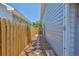 This side yard features a wooden fence, stone path, gravel, and access to the backyard at 3053 S Concordia Ave # A, Tampa, FL 33629