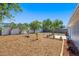 Large backyard featuring a patio, wood-mulched areas, and a white fence at 3401 Truman Dr, Holiday, FL 34691
