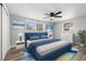 Bedroom with blue accents, light walls, ceiling fan, and wood-look floors at 3401 Truman Dr, Holiday, FL 34691