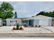 Charming single-story home featuring a blue exterior, well-manicured lawn, and a white garage door at 3401 Truman Dr, Holiday, FL 34691
