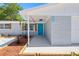 Close-up of the home's entrance, featuring a bright blue door, modern fixtures, and neatly landscaped yard at 3401 Truman Dr, Holiday, FL 34691