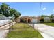 Charming single-story home with a well-manicured front lawn, a garage, and fenced yard at 4208 W Flora St, Tampa, FL 33614