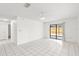 Open living area with tiled floors, a ceiling fan, and sliding glass doors to the backyard at 4208 W Flora St, Tampa, FL 33614
