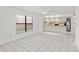 Bright open-concept living space with tile flooring, a large window, and kitchen access at 4208 W Flora St, Tampa, FL 33614