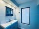 Modern bathroom features a stylish blue vanity with a white countertop and ample storage at 4360 Outrigger Ln, Tampa, FL 33615