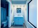 Well-lit bathroom with blue vanity, modern fixtures, and a shower area at 4360 Outrigger Ln, Tampa, FL 33615