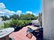 Outdoor patio area with furniture, lush greenery, and an umbrella for shade at 4360 Outrigger Ln, Tampa, FL 33615