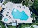 Aerial view of large community pool with lounge chairs and tables near mature trees at 4360 Outrigger Ln, Tampa, FL 33615