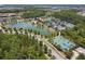 Scenic aerial view of community amenities including a lake, tennis courts, basketball court, and clubhouse with pool at 4583 Barletta Ct, Wesley Chapel, FL 33543