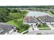 Aerial view of a lakeside home with manicured lawn and three-car garage in a gated community at 4583 Barletta Ct, Wesley Chapel, FL 33543