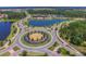 Aerial view of a community, showing the manicured landscaping, water features, and circular driveway at the entrance at 4583 Barletta Ct, Wesley Chapel, FL 33543