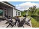 Paver patio with a fire pit, grill, screen porch and view of the backyard landscaping at 4583 Barletta Ct, Wesley Chapel, FL 33543