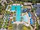 Aerial view of a community pool with palm trees, slides, lounge chairs, and shaded cabanas in a tropical setting at 4583 Barletta Ct, Wesley Chapel, FL 33543