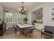 Bright dining room with stylish lighting, a wine bar, and seating for eight by the windows at 4583 Barletta Ct, Wesley Chapel, FL 33543