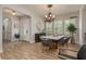 Dining room with wood floors, a modern chandelier, and plantation shutters on the windows at 4583 Barletta Ct, Wesley Chapel, FL 33543