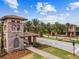 Community entrance with stone tower, tiled roof, and palm trees, exemplifying upscale residential living at 4583 Barletta Ct, Wesley Chapel, FL 33543