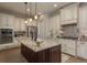 Spacious kitchen features an island with a granite countertop, stainless steel appliances, and custom cabinetry at 4583 Barletta Ct, Wesley Chapel, FL 33543