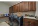 A well-equipped laundry room features modern washer and dryer units and ample cabinetry at 4583 Barletta Ct, Wesley Chapel, FL 33543