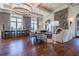 Spacious living room with hardwood floors, stone fireplace, large windows, and stylish bar seating area at 4583 Barletta Ct, Wesley Chapel, FL 33543