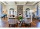 Cozy living room with hardwood floors, a stone fireplace, large windows, and comfortable seating arrangements at 4583 Barletta Ct, Wesley Chapel, FL 33543