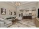 Spacious living room open to the kitchen featuring hardwood floors, an elegant chandelier, and stylish decor at 4583 Barletta Ct, Wesley Chapel, FL 33543