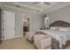 An inviting bedroom features a tufted headboard, tray ceiling, and doorway to the ensuite bathroom at 4583 Barletta Ct, Wesley Chapel, FL 33543