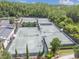Aerial view of well-maintained tennis courts surrounded by lush landscaping and trees at 4583 Barletta Ct, Wesley Chapel, FL 33543
