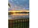 A picturesque lake view from a backyard, capturing the sunset, community homes, and a serene environment at 4583 Barletta Ct, Wesley Chapel, FL 33543