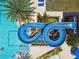 Aerial view of a fun waterslide at a community pool, showing a person sliding down into the water below at 4583 Barletta Ct, Wesley Chapel, FL 33543