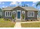 Charming home featuring a blue front door, landscaped yard, and brick pathway at 475 28Th N Ave, St Petersburg, FL 33704