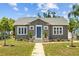 Inviting home exterior featuring a brick pathway, landscaped yard, and a charming blue front door at 475 28Th N Ave, St Petersburg, FL 33704