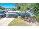 Charming one-story blue home with a carport, driveway, front yard, and mature shade tree in a sunny neighborhood at 489 Fox Run Trl, Apollo Beach, FL 33572