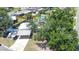 Aerial view of home with carport, driveway, and fenced-in pool area, surrounded by mature trees and neighborhood homes at 489 Fox Run Trl, Apollo Beach, FL 33572