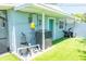 The artificial turf backyard features a pool pump, turquoise door, and an exercise bike at 489 Fox Run Trl, Apollo Beach, FL 33572