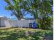 Backyard view of the white privacy fence bordering a yard with black and blue garbage cans at 489 Fox Run Trl, Apollo Beach, FL 33572