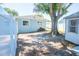 Back exterior featuring a large shade tree over a shed with white fence surrounding at 489 Fox Run Trl, Apollo Beach, FL 33572