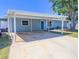 Charming single-story home featuring a covered carport and freshly painted exterior with blue door at 489 Fox Run Trl, Apollo Beach, FL 33572