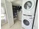 Bright laundry room with stacked washer and dryer and shelving for storage at 489 Fox Run Trl, Apollo Beach, FL 33572