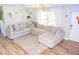Bright living room with hardwood floors, a large sectional sofa, and natural light at 489 Fox Run Trl, Apollo Beach, FL 33572