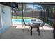 A screened lanai offers a dining set beside the sparkling pool surrounded by lush greenery in the fenced backyard at 489 Fox Run Trl, Apollo Beach, FL 33572