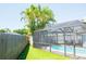 Screened pool area with blue water and lounge chairs surrounded by green plants and blue skies at 489 Fox Run Trl, Apollo Beach, FL 33572