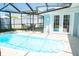 A screened pool with a patio table and chairs in an enclosed backyard with turf at 489 Fox Run Trl, Apollo Beach, FL 33572