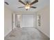 This bedroom features neutral walls, tile floors, ceiling fan, closet and view to the bathroom at 4976 Cedarbrook Ln, Hernando Beach, FL 34607