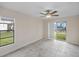 Bright room featuring tiled flooring, ceiling fan, window, and a sliding glass door to the backyard at 4976 Cedarbrook Ln, Hernando Beach, FL 34607