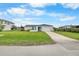 Charming single-story home with a well-manicured lawn, a driveway, and a bright blue front door at 4976 Cedarbrook Ln, Hernando Beach, FL 34607